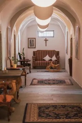 a church with a bench and a cross in a room at Residence Traube in Bressanone