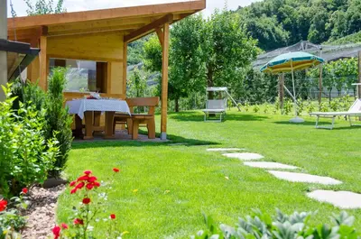 a garden with a picnic table and an umbrella at Haus Stolz in Appiano sulla Strada del Vino