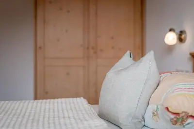 a bed with two pillows on top of it at Haus Stolz in Appiano sulla Strada del Vino