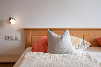 a bed with two pillows on top of it at Haus Stolz in Appiano sulla Strada del Vino
