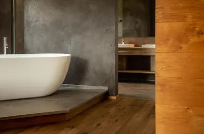 a bathroom with a white bath tub on a wooden floor at Romantik Chalet im Weingut Eichenstein in Merano