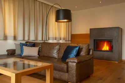 a living room with a couch and a fireplace at Romantik Chalet im Weingut Eichenstein in Merano