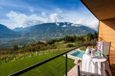 a balcony with a table and a view of a mountain at Romantik Chalet im Weingut Eichenstein in Merano