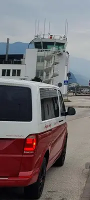 a white and red van parked in front of a ship at Hofer Hof in Andrian