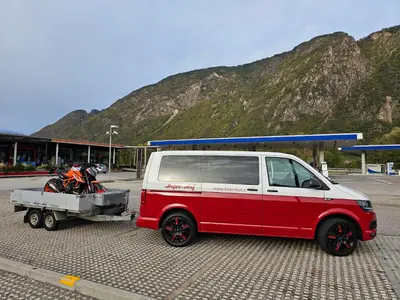 a red and white van with a motorcycle on a trailer at Hofer Hof in Andrian