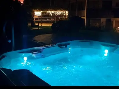 a blue hot tub in a yard at night at Hofer Hof in Andrian