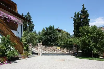 a house with a stone wall and a fence at Hofer Hof in Andrian