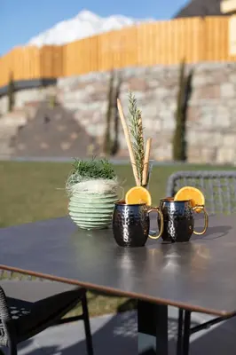 three coffee mugs sitting on a table with oranges at Appartments mir.es in Tirolo