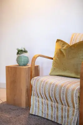 a couch with a pillow and a plant on a table at Appartments mir.es in Tirolo