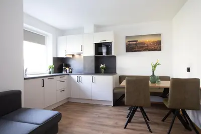 a kitchen and dining room with a table and chairs at Appartments mir.es in Tirolo