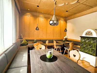 a dining room with a wooden table and chairs at Appartments mir.es in Tirolo