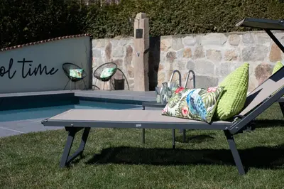 a ping pong table in the grass next to a pool at Appartments mir.es in Tirolo