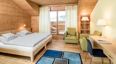 a hotel room with a bed and a desk and a table at Seiser Alm Urthaler in Alpe di Siusi