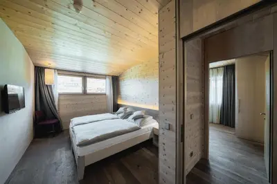 a bedroom with two beds and a wooden ceiling at Seiser Alm Urthaler in Alpe di Siusi