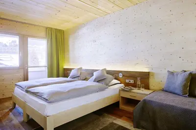 a bedroom with a large bed and a window at Seiser Alm Urthaler in Alpe di Siusi
