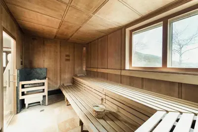 a sauna with wooden walls and windows and a bench at Seiser Alm Urthaler in Alpe di Siusi