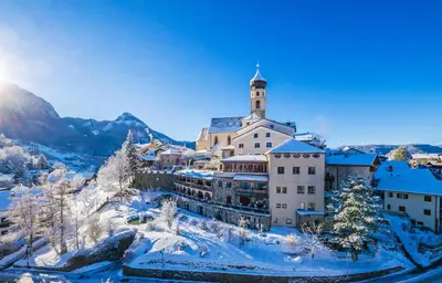 a building on top of a mountain in the snow at Romantik Hotel Turm in Fiè
