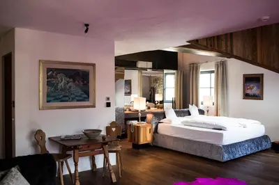 a bedroom with a large bed and a table at Romantik Hotel Turm in Fiè