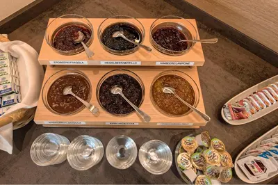a group of four bowls of food with spoons at Pension Irma in Caldaro