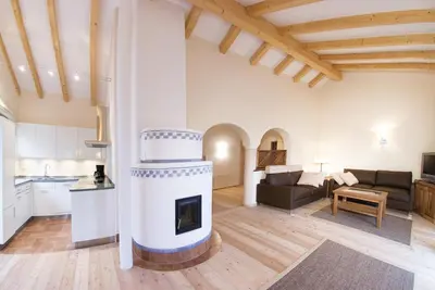 a kitchen and a living room with a fireplace at Ansitz Waldner Oberwirt in Marlengo