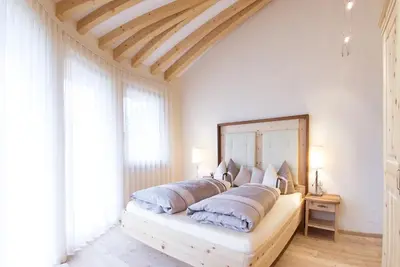 a bedroom with a large bed with a large mirror at Ansitz Waldner Oberwirt in Marlengo