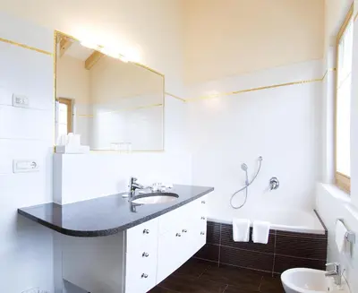 a white bathroom with a sink and a mirror at Ansitz Waldner Oberwirt in Marlengo