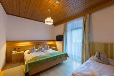 a hotel room with a bed and a tv at Alpin Natur Hotel Brückele in Braies