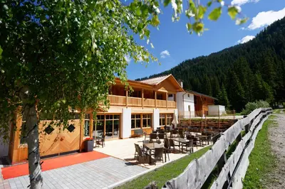 a large building in the snow with snow covered ground at Alpin Natur Hotel Brückele in Braies