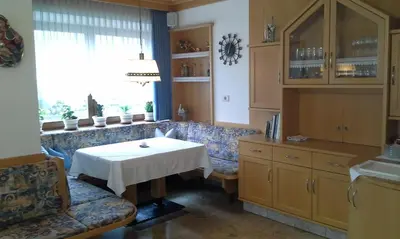 a living room with a table and a couch and a window at Garni Schwarzenstein in Campo Tures