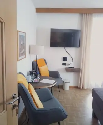 a room with two chairs and a table and a tv at Garni Schwarzenstein in Campo Tures