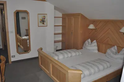 a bedroom with a large bed with a mirror at Garni Schwarzenstein in Campo Tures