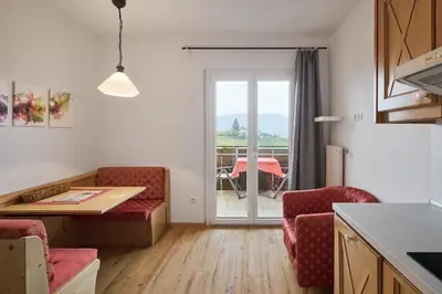 a kitchen with two chairs and a table with a view at Apartments in Kaltern, Panorama-Terrasse mit Bergblick nahe Zentrum in Caldaro