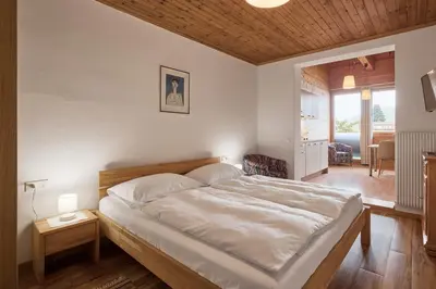 a bedroom with a large bed with a wooden ceiling at Apartments in Kaltern, Panorama-Terrasse mit Bergblick nahe Zentrum in Caldaro