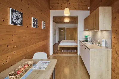 a kitchen with wooden walls and a bed in the background at Apartments in Kaltern, Panorama-Terrasse mit Bergblick nahe Zentrum in Caldaro