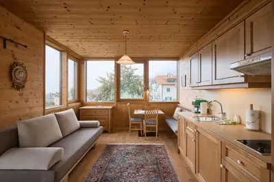 a kitchen and living room with a couch and a table at Apartments in Kaltern, Panorama-Terrasse mit Bergblick nahe Zentrum in Caldaro