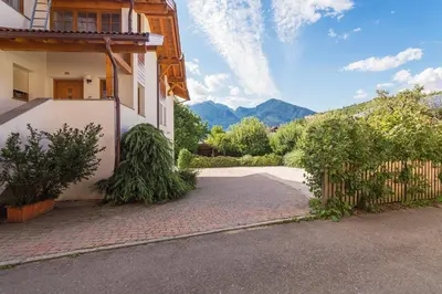 a house with a fence next to a driveway at Kienasthof in Bressanone