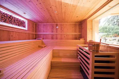 an empty wooden sauna with a window at Hotel Kranebitt B&B in Bressanone