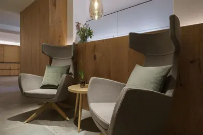 a living room with two chairs and a table at Hotel Kranebitt B&B in Bressanone