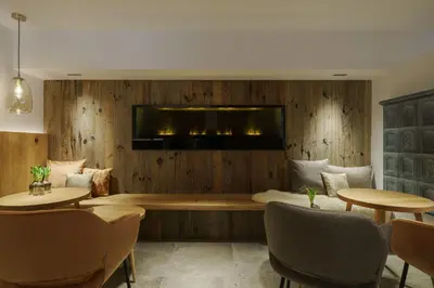 a living room with wood paneling and a television on a wall at Hotel Kranebitt B&B in Bressanone
