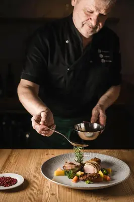 a man holding a spoon and a plate of food at Familienhotel Viktoria in Ultimo