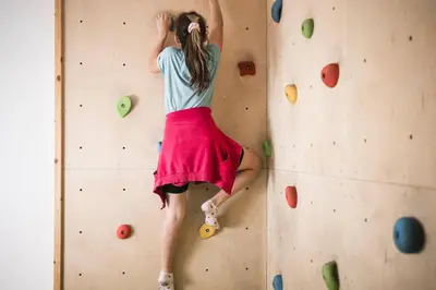 a girl is climbing a rock wall at Familienhotel Viktoria in Ultimo