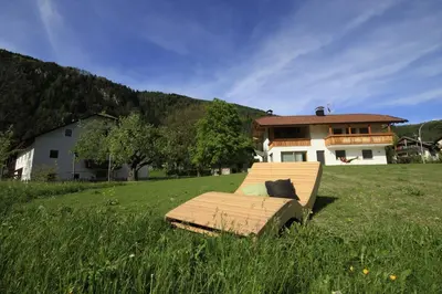 a bed in a field in front of a house at Pitterlehof in Chienes