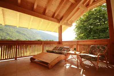 a porch with a bench and a table and chairs at Pitterlehof in Chienes