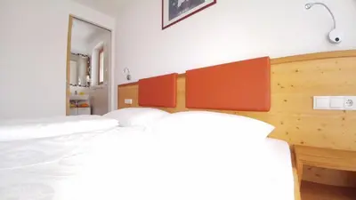 a bedroom with a white bed and a mirror at Pitterlehof in Chienes