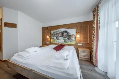 a bedroom with a bed with towels on it at Hotel Pension Odles in San Martino in Badia
