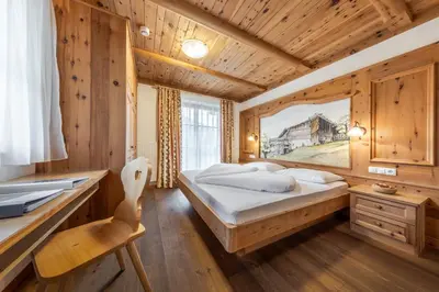a bedroom with a bed and a desk at Hotel Pension Odles in San Martino in Badia