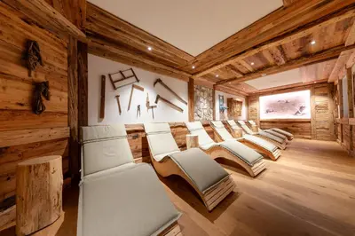 a row of chairs in a room with wooden walls at Hotel Pension Odles in San Martino in Badia