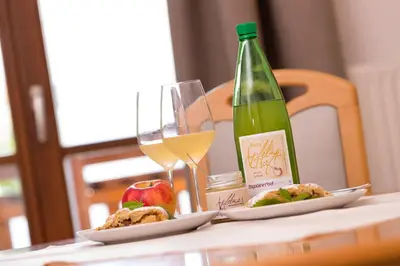 a table with two plates of food and a bottle of wine at Engadiner Apartments & Wines in Montagna