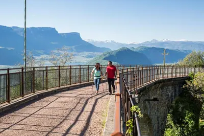 a man and a woman walking on a bridge at Engadiner Apartments & Wines in Montagna