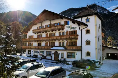 a large building with cars parked in front of it at Hotel Resa Blancia in San Vigilio Di Marebbe
